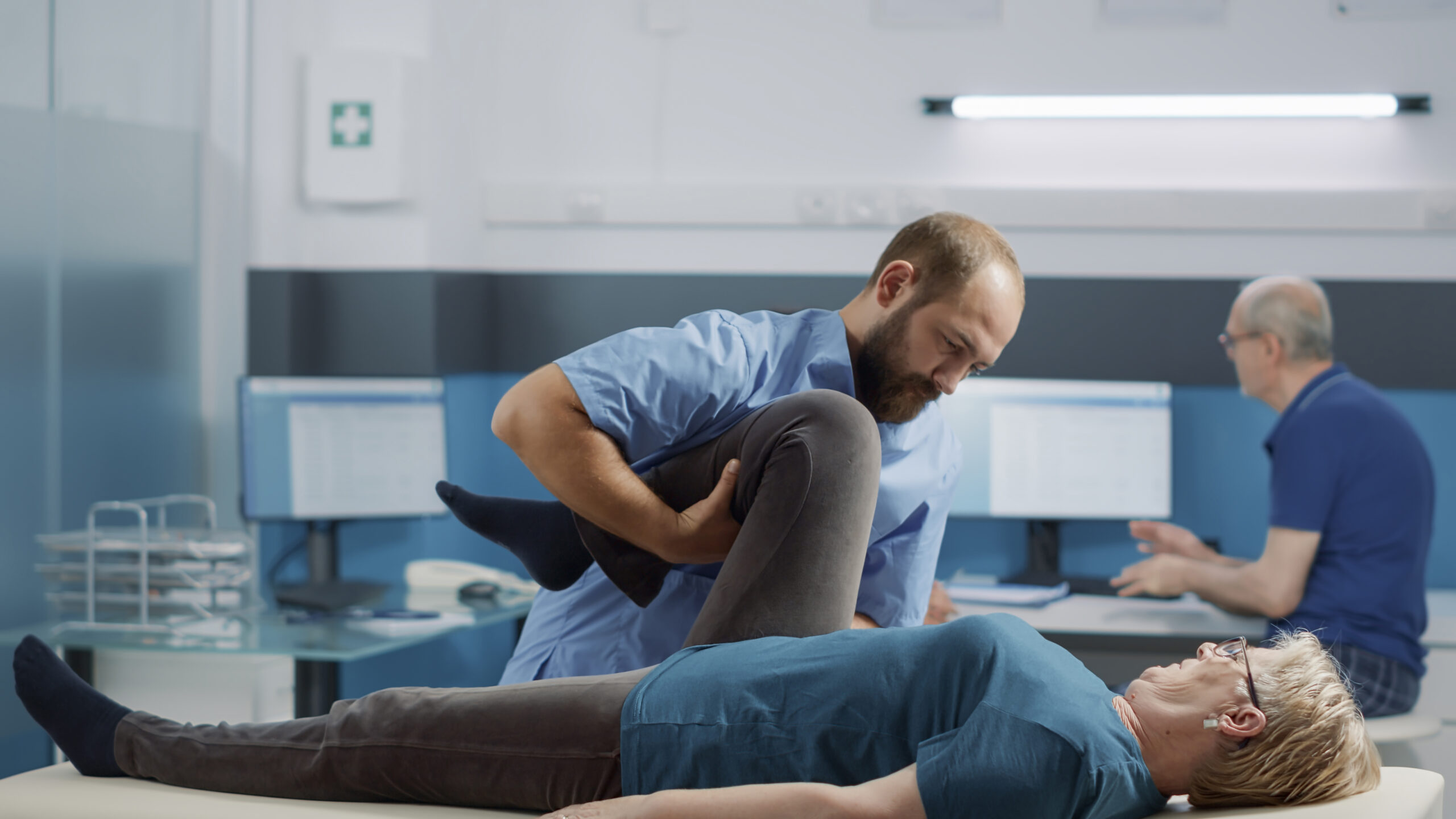 Medical specialist helping elder patient to cure physical injury